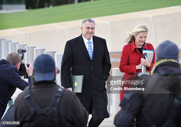 Joe Hockey, Australia's treasurer, center, arrives at Parliament House with his media advisor Jennifer Clark, right, ahead of delivering the...
