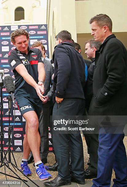 James Hird, coach of the Bombers squeezes past AFL reporter Mark Stevens and the media after speaking to them during an Essendon Bombers AFL recovery...