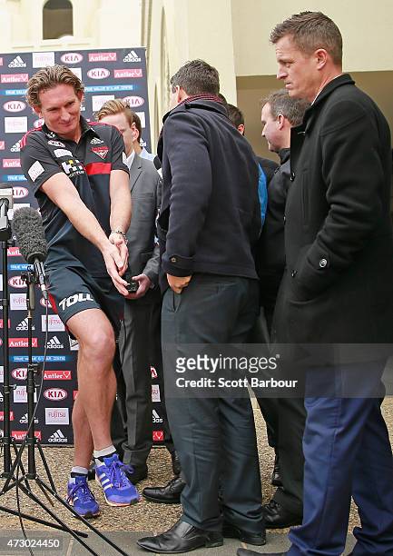 James Hird, coach of the Bombers squeezes past AFL reporter Mark Stevens and the media after speaking to them during an Essendon Bombers AFL recovery...