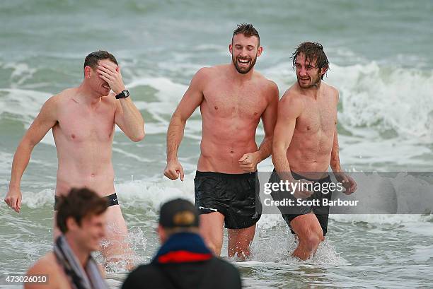 Brendon Goddard, Cale Hooker and Jobe Watson, captain of the Bombers wade in the water during an Essendon Bombers AFL recovery session at St Kilda...