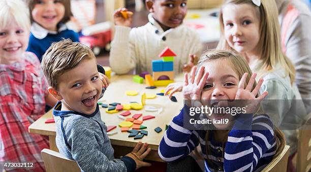 playful preschoolers having fun making faces - classroom play stockfoto's en -beelden