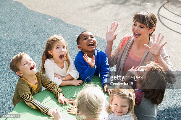 enseignante de maternelle enfants s'amusant - sing outside photos et images de collection