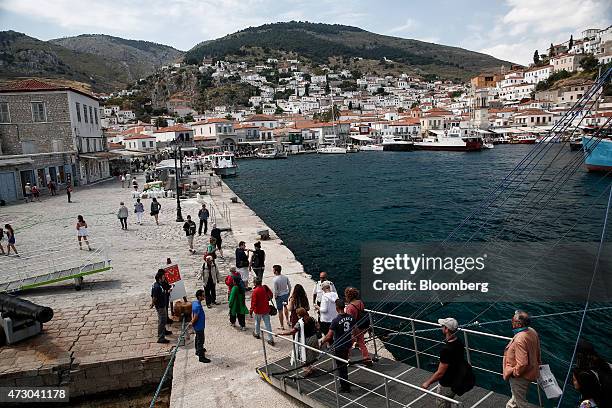 Tourists disembark from a cruise ship after travelling from Athens on the island of Hydra, Greece, on Monday, May 11, 2015. Less than three weeks...