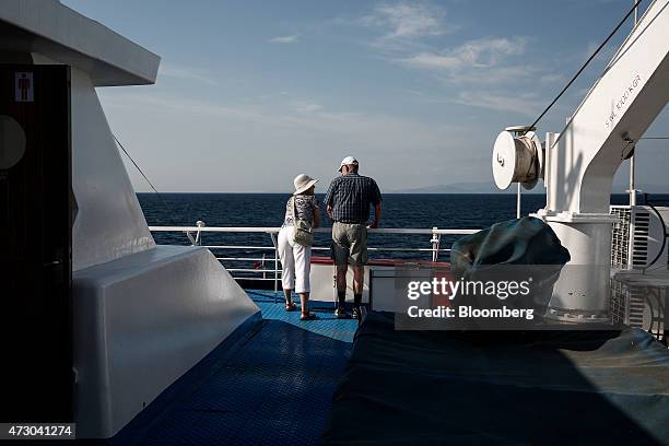 Tourists look out across the sea as they stand aboard a cruise ship sailing in the Saronic gulf west of Athens, Greece, on Monday, May 11, 2015. Less...