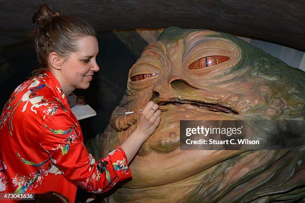 Member of staff makes a last minute touch up of wax figure Jabba The Hut, from Star Wars, on display at 'Star Wars At Madame Tussauds' on May 12,...