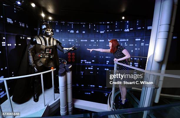 Fan poses with a wax figure of Star Wars character Darth Vader at 'Star Wars At Madame Tussauds' on May 12, 2015 in London, England.