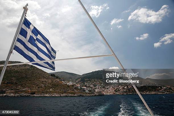 Greek national flag flies from the bow of a cruise ship as it leaves the port of Hydra, Greece, on Monday, May 11, 2015. Less than three weeks after...