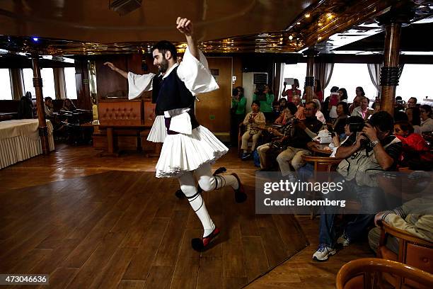 Dancer wearing traditional Greek costume performs for tourists aboard a cruise ship sailing west of Athens, Greece, on Monday, May 11, 2015. Less...