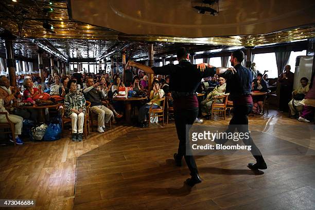 Dancers perform traditional Greek dances for tourists aboard a cruise ship sailing west of Athens, Greece, on Monday, May 11, 2015. Less than three...