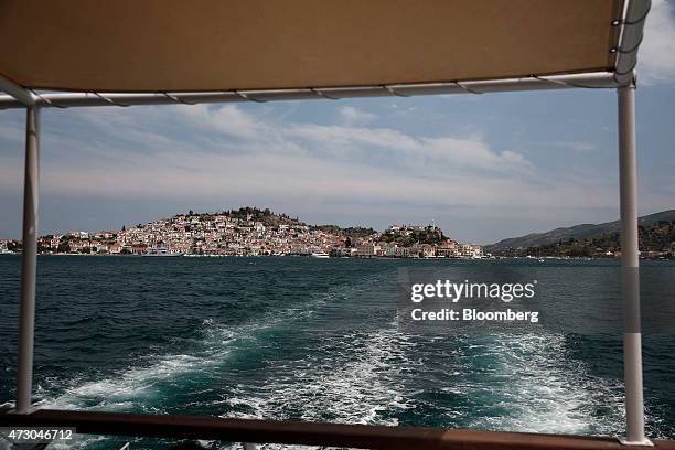 Buildings sit on the harbor side seen from a cruise ship departing the island of Poros, Greece, on Monday, May 11, 2015. Less than three weeks after...