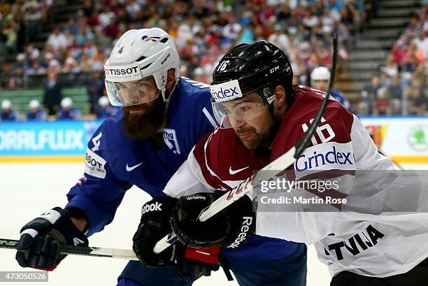 Kaspars Daugavins of Latvia and Antonin Manavian of France battle for the puck during the IIHF World Championship group A match between Latvia and...