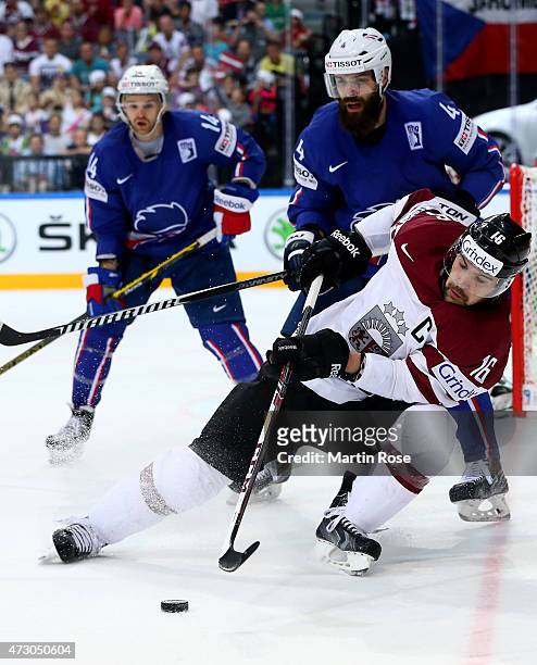 Kaspars Daugavins of Latvia and Antonin Manavian of France battle for the puck during the IIHF World Championship group A match between Latvia and...