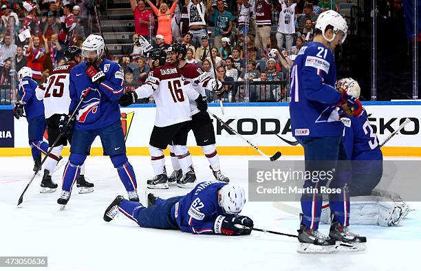 Kaspars Daugavins of Latvia celebrate with his team mates after he scores the opening goal during the IIHF World Championship group A match between...