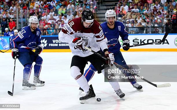 Rodrigo Abols of Latvia and Jonathan Janil of France battle for the puck during the IIHF World Championship group A match between Latvia and France...