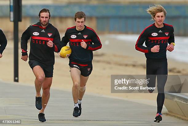 Jobe Watson, Zach Merrett and Dyson Heppell of the Bombers run during an Essendon Bombers AFL recovery session at St Kilda Sea Baths on May 12, 2015...