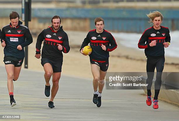 Jobe Watson, Zach Merrett and Dyson Heppell of the Bombers run during an Essendon Bombers AFL recovery session at St Kilda Sea Baths on May 12, 2015...