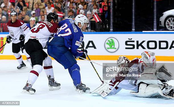 Edgars Masalskis , goaltender of Latvia makes a save on Charles Bertrand of France battle for the puck during the IIHF World Championship group A...