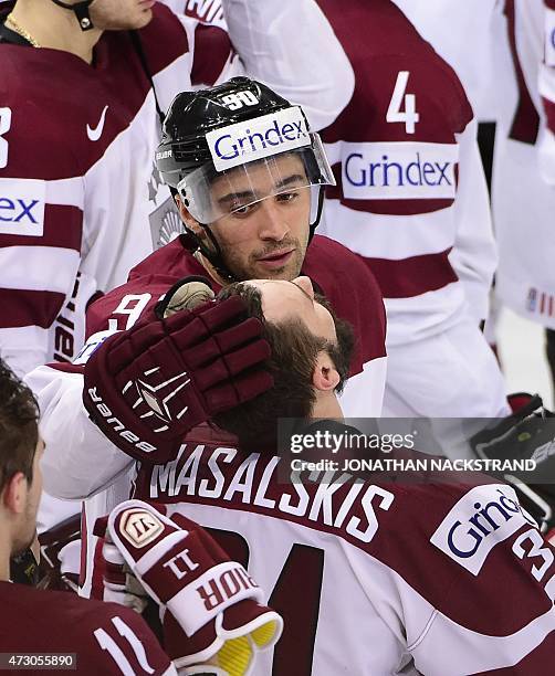 Forward Koba Jass comforts his teammate goalkeeper Edgars Masalskis of Latvia after loosing a penalty shootout during the group A preliminary round...