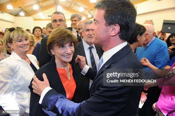 French Prime Minister Manuel Valls speaks with former minister Michele Delaunay during a meeting with socialist militants on May 12, 2015 in Cenon....