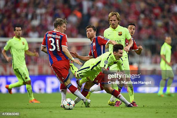 Lionel Messi of Barcelona is challenged by Xabi Alonso and Bastian Schweinsteiger of Bayern Muenchen during the UEFA Champions League semi final...