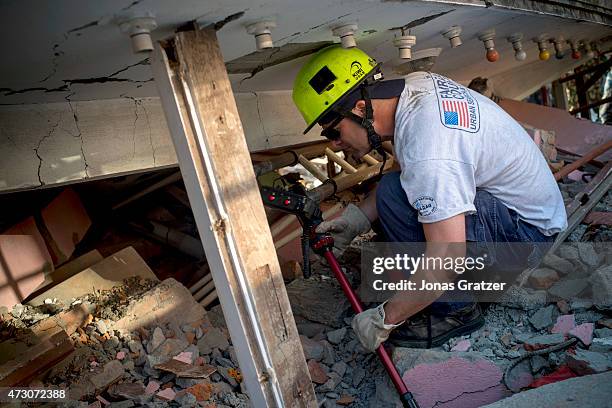 Rescue team searches for a young boy who is believed to be trapped under the rubble of a house that collapsed following a second major earthquake May...