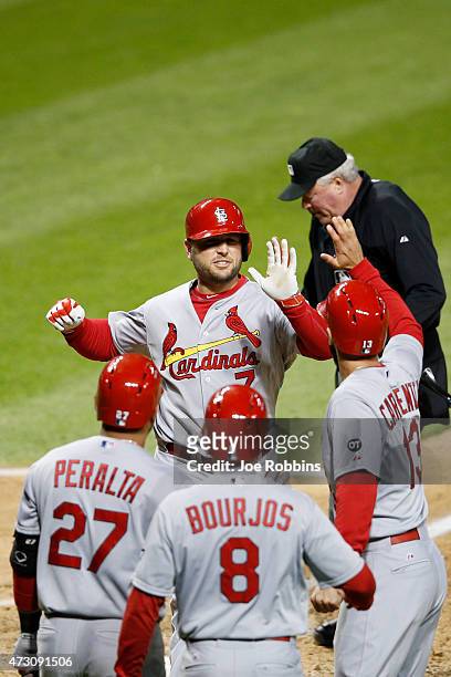 Matt Holliday of the St. Louis Cardinals celebrates with teammates after hitting a three-run homer in the eighth inning of the game against the...