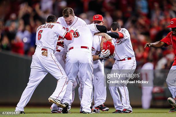 Members of the Cincinnati Reds celebrate with Devin Mesoraco of the Cincinnati Reds after hitting the game winning run during the ninth inning...