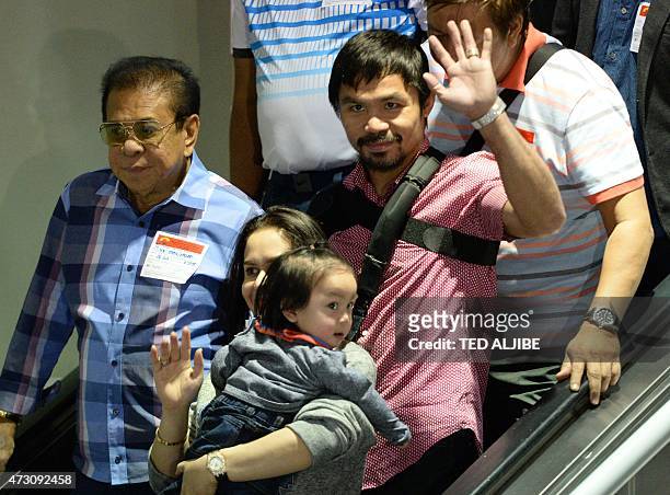 Boxing icon Manny Pacquiao of the Philippines and his wife Jinkee wave to photographers shortly after arriving from the US at the international...
