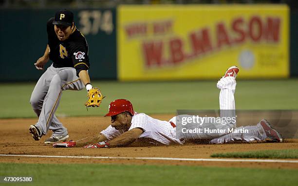 Ben Revere of the Philadelphia Phillies slides safely into third base as Jung Ho Kang of the Pittsburgh Pirates attempts to make the tag in the sixth...