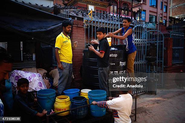 Nepalese people fill their buckets with water following the second major earthquake in Kathmandu, Nepal on May 13, 2015. The second major earthquake...