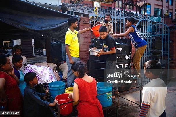Nepalese people fill their buckets with water following the second major earthquake in Kathmandu, Nepal on May 13, 2015. The second major earthquake...
