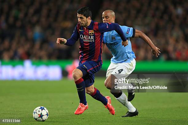 Luis Suarez of Barcelona battles with Vincent Kompany of Man City during the UEFA Champions League Round of 16 match between FC Barcelona and...