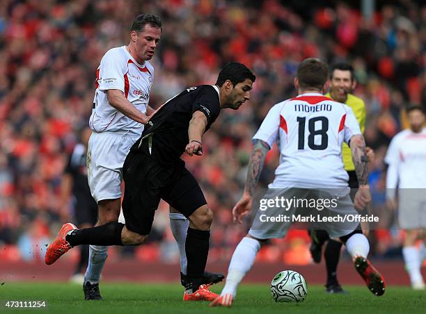 Luis Suarez battles with Jamie Carragher during the Liverpool All-Star Charity match at Anfield on March 29, 2015 in Liverpool, England.