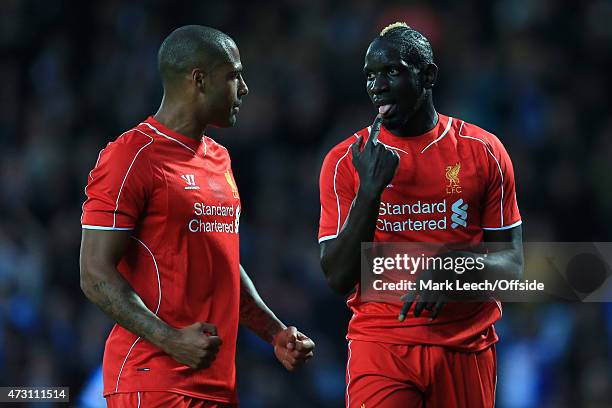 Mamadou Sakho of Liverpool gestures to teammate Glen Johnson during the FA Cup Quarter Final Replay match between Blackburn Rovers and Liverpool at...