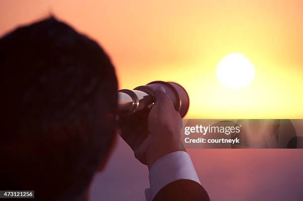 businessman looking to the future with telescope at sunrise. - telescope stock pictures, royalty-free photos & images