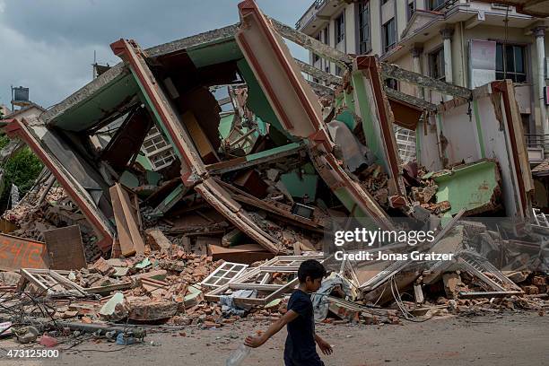 People walk past the rubble following yesterday's earthquake on May 13, 2015 in Kathmandu, Nepal. A 7.3 magnitude earthquake struck in Nepal only two...