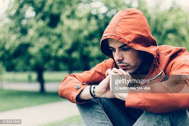 depressed man in the park - embarrassment stock pictures, royalty-free photos & images