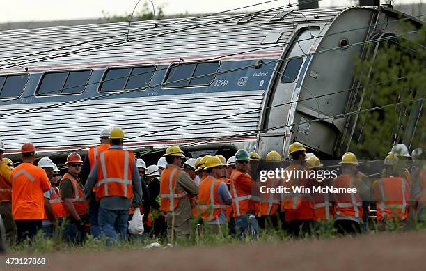 Investigators and first responders work near the wreckage of an Amtrak passenger train carrying more than 200 passengers from Washington, DC to New...