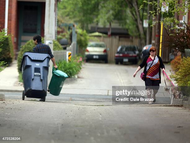 Jian Ghomeshi is seen on Monday hauling a recycling bin and a compost bin near a home he owns in Upper Beach.
