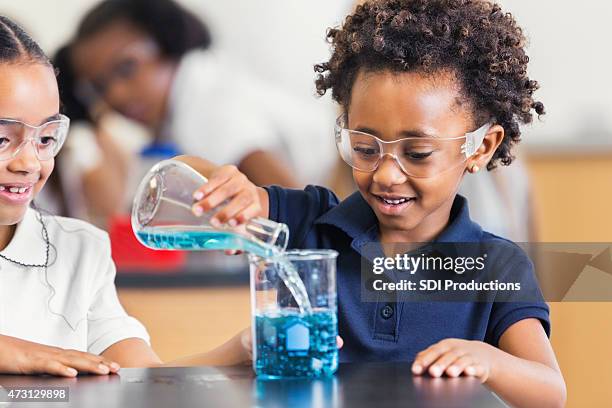 afro-americano fazendo experimentos química aluna na aula de ciências primária - chemistry class - fotografias e filmes do acervo