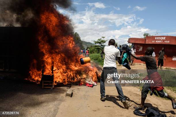 People burn mattresses looted from the local police post on 13 May in Musaga neighborhood in Bujumbura, during a protest against incumbent president...