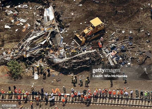 Investigators and first responders work near the wreckage of Amtrak Northeast Regional Train 188, from Washington to New York, that derailed...