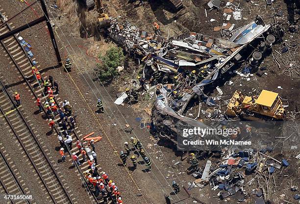 Investigators and first responders work near the wreckage of an Amtrak passenger train carrying more than 200 passengers from Washington, DC to New...