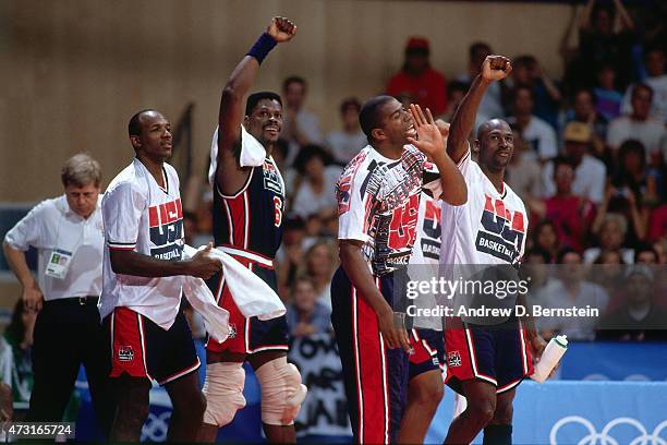 Clyde Drexler, Patrick Ewing, Magic Johnson, and Michael Jordan of the U.S. Mens Olympic Basketball Team cheer circa 1992 during the 1992 Summer...