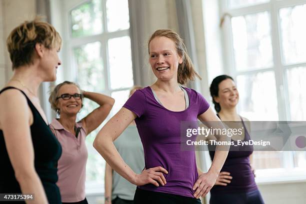 happy women talking while relaxing in gym - arms akimbo stock pictures, royalty-free photos & images