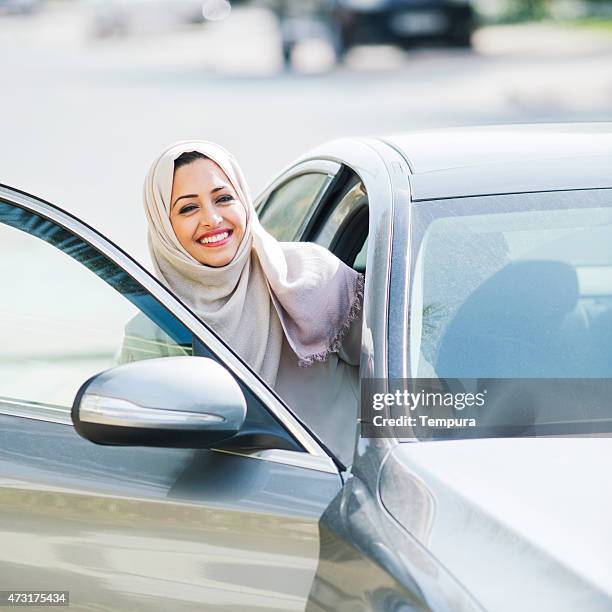 middle easter woman entering a luxury car in dubai - dubai woman driving car stockfoto's en -beelden