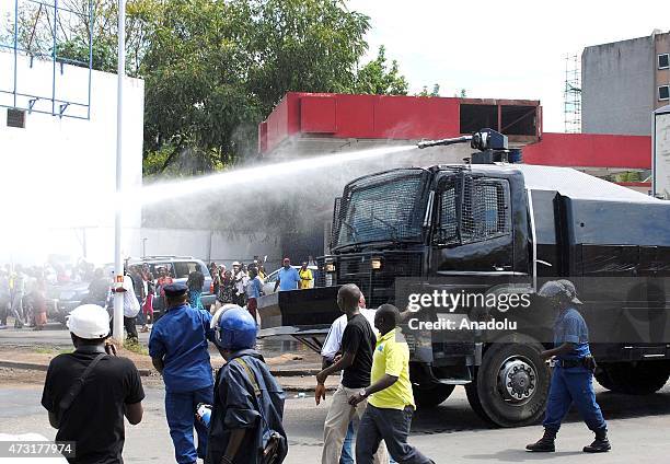 Burundian security forces spray water from a water cannon as people cheer over the coup allegations in Bujumbura, Burundi on May 13, 2015 after Major...