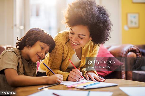 smiling african american mother and son coloring together. - child's drawing stock pictures, royalty-free photos & images