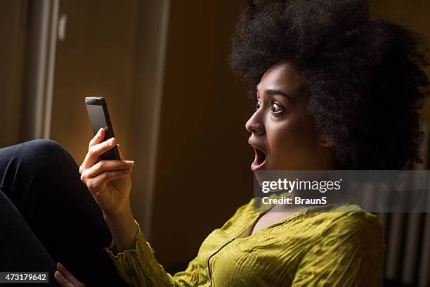 femme afro-américaine à son reçu un message texte. - beautiful woman shocked photos et images de collection