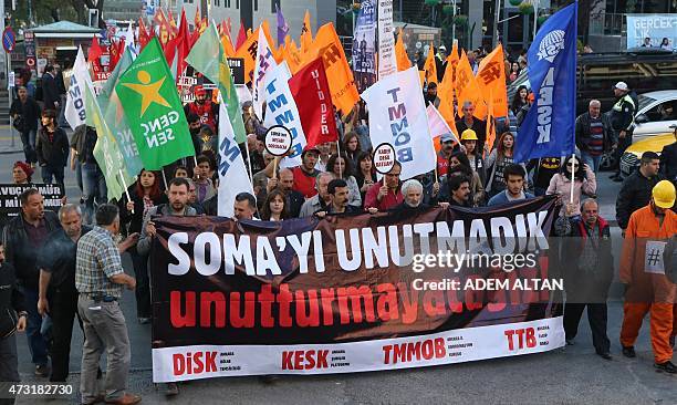 People hold flags and a banner reading 'We will not forget Soma' as they take part in a march in memory of miners who died in an explosion at the...